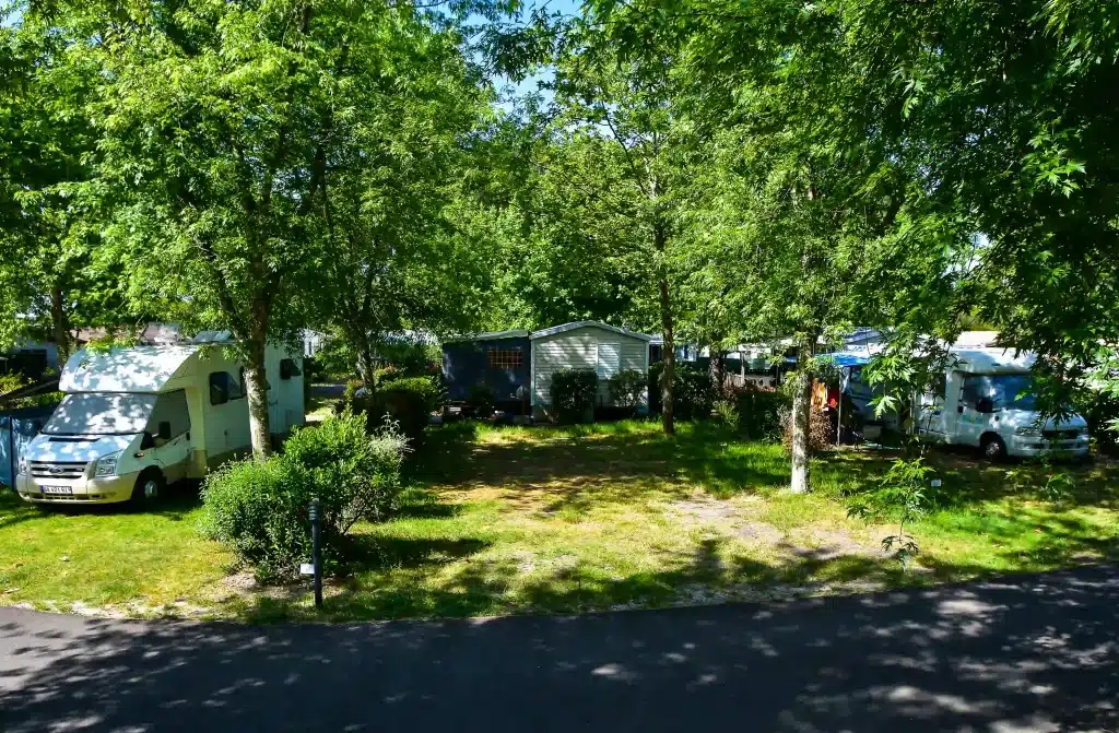 Emplacement camping à Biscarrosse ombragé sous les pins.